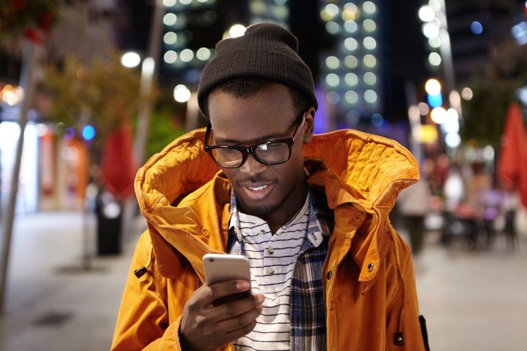 headshot-handsome-young-afro-american-student-having-walk-around-night-city-holding-mobile-phone-using-urban-wifi-browsing-pictures-social-media-modern-technology-communication_273609-1317